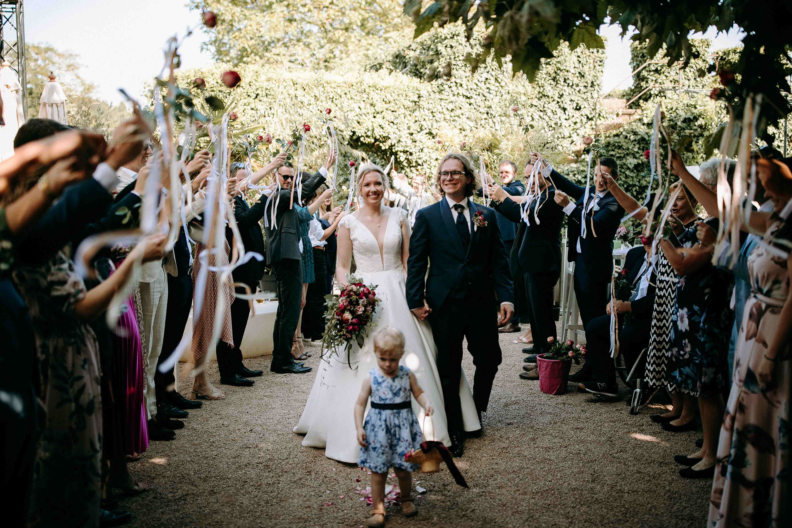 Hochzeitsgäste begrüßen Brautpaar bei Burg Crass mit Rosen und Bändern – emotionaler Moment im Rheingau.