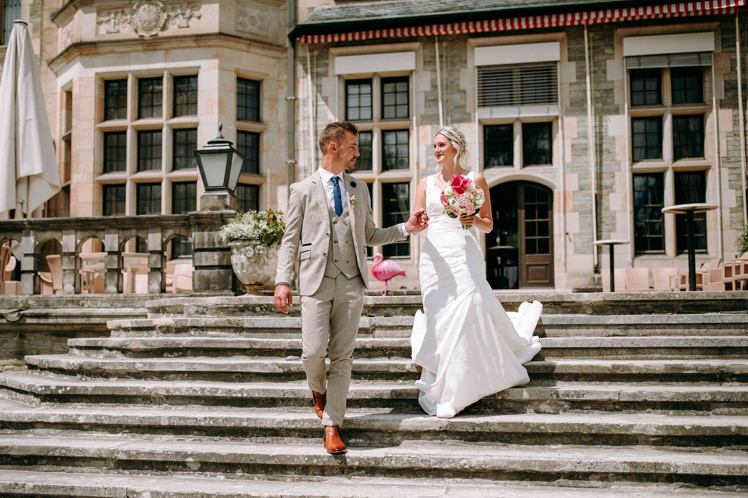 Braut und Bräutigam beim Abstieg der Steintreppe des Schlosshotels Kronberg – Hochzeitsfotografie pur.