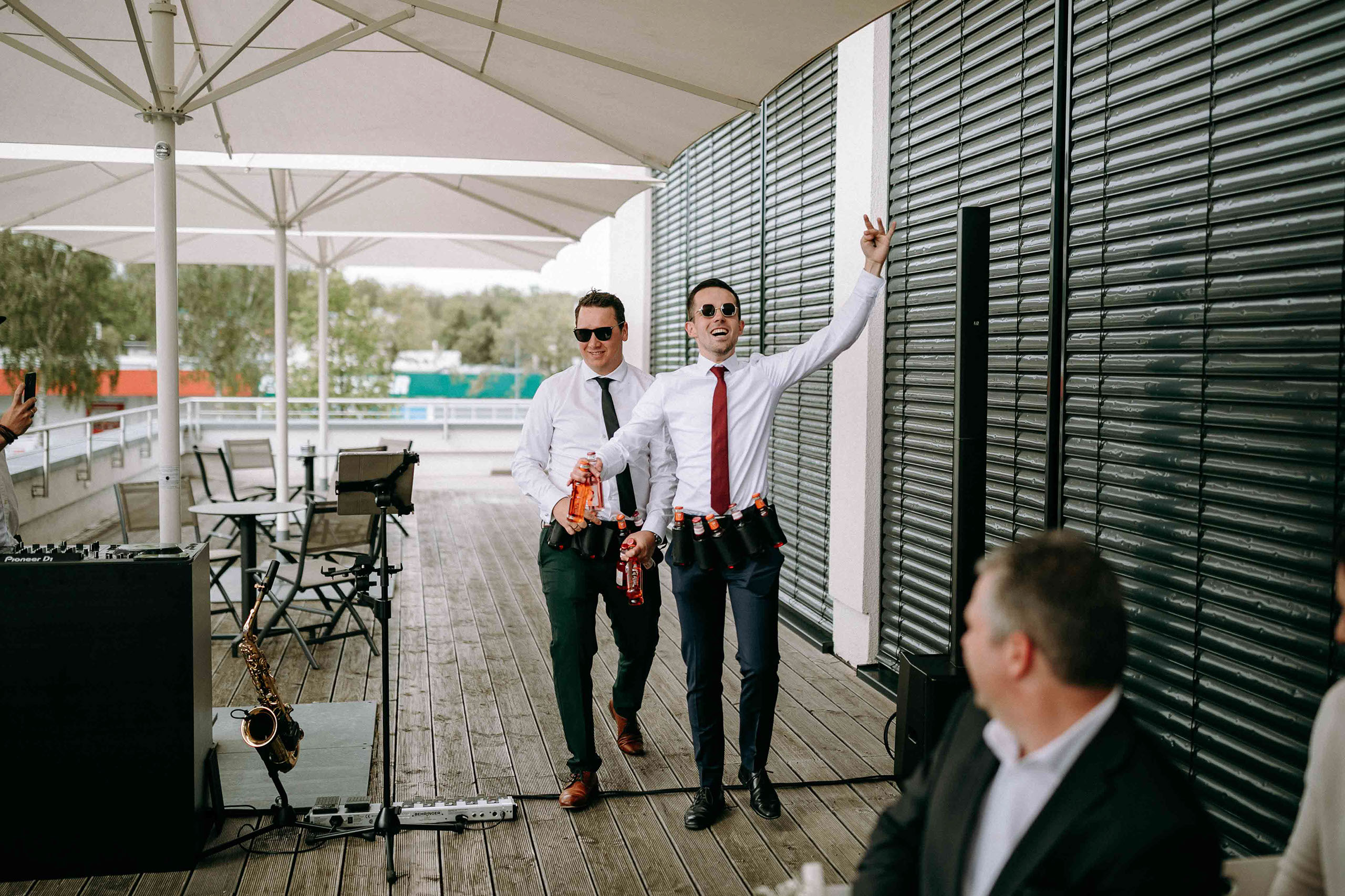 Die Trauzeugen bringen vor der Trauung mit Bauchlaeden und Getraenken gute Stimmung auf die Dachterrasse