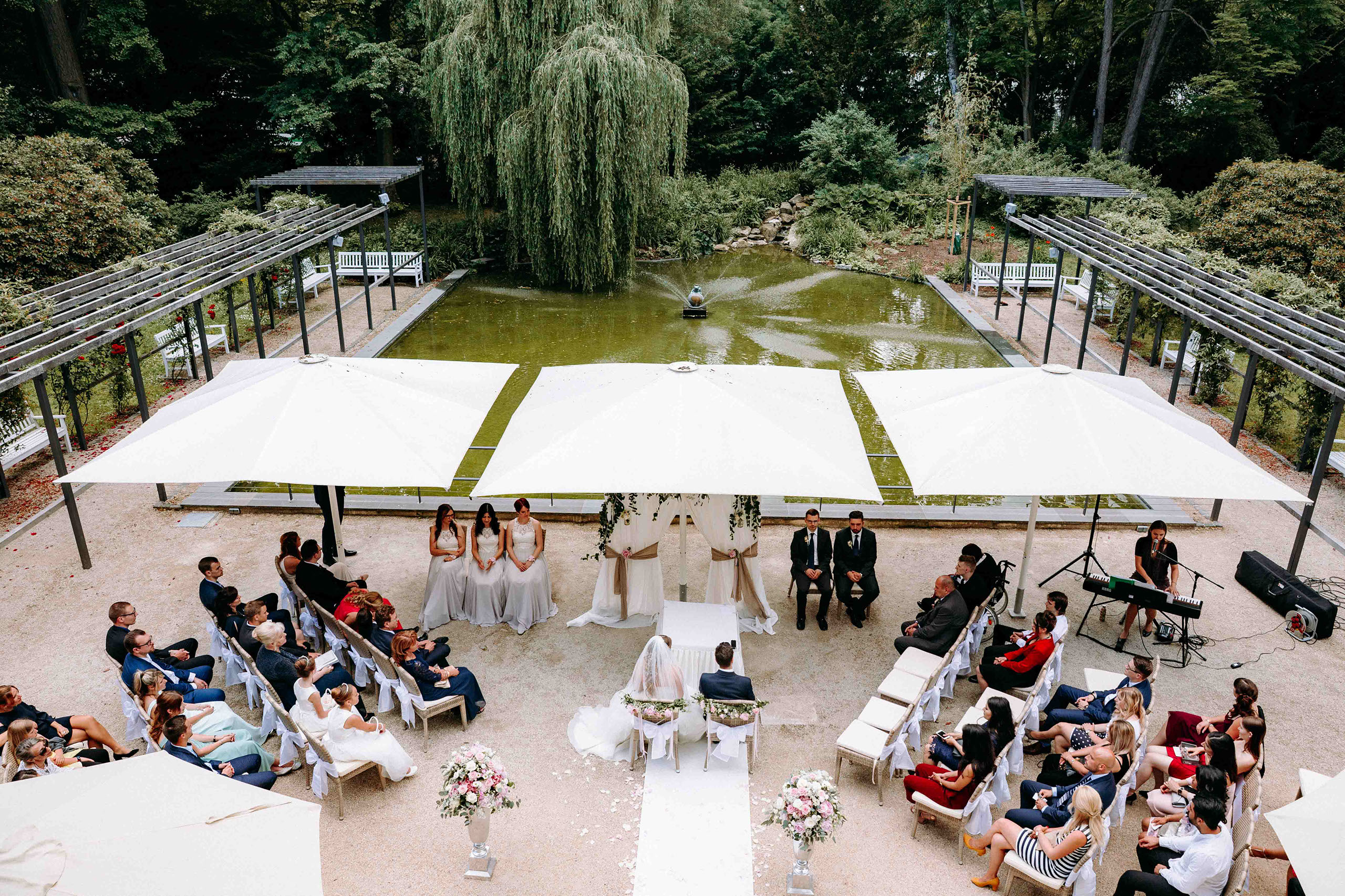 Gäste sitzen bei Hochzeitszeremonie im Kurpark Bad Homburg in der Orangerie