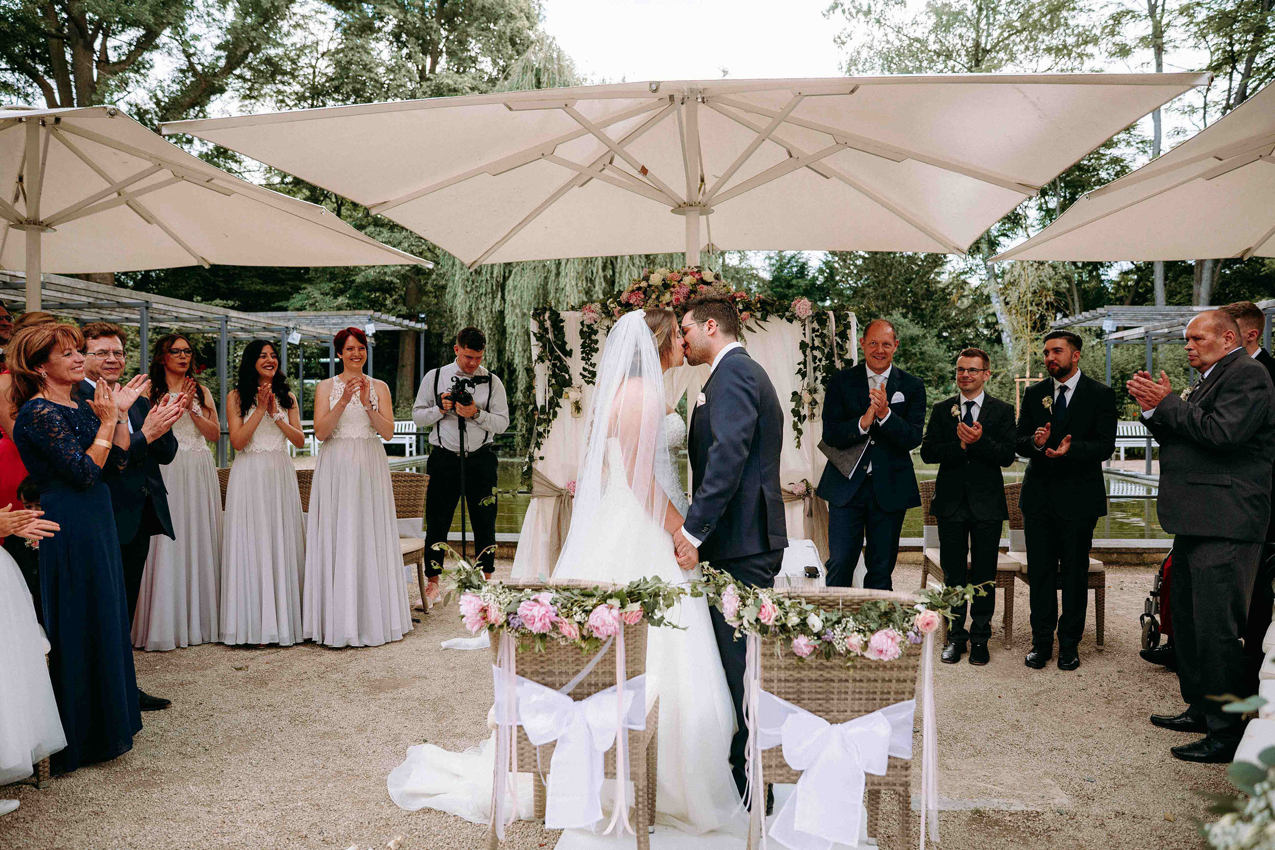 Brautpaar küsst sich bei der freien Trauung vor Gästen in der Orangerie Bad Homburg