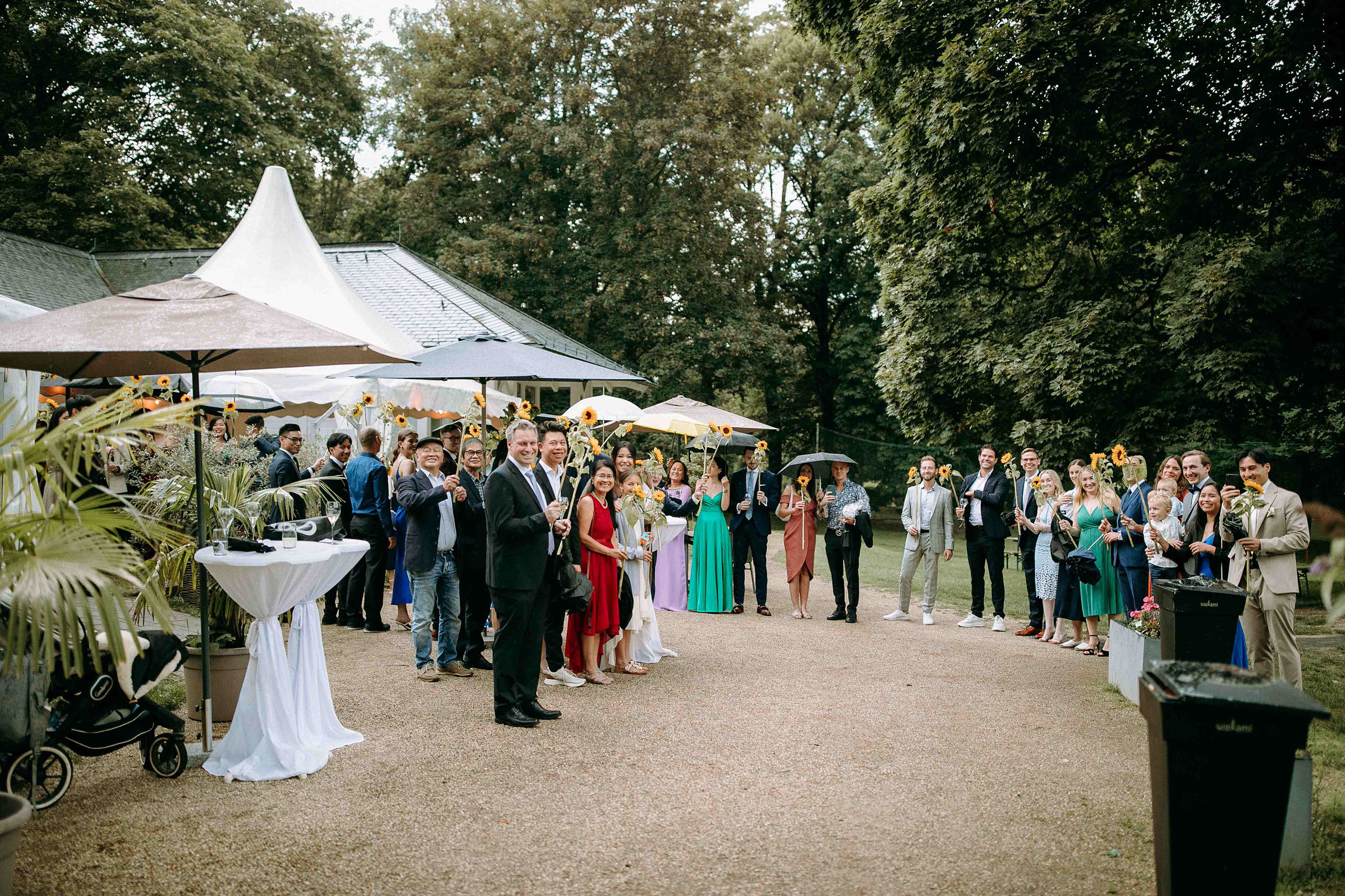 Gäste halten Sonnenblumen beim Empfang vor dem Golfhaus Restaurant Bad Homburg
