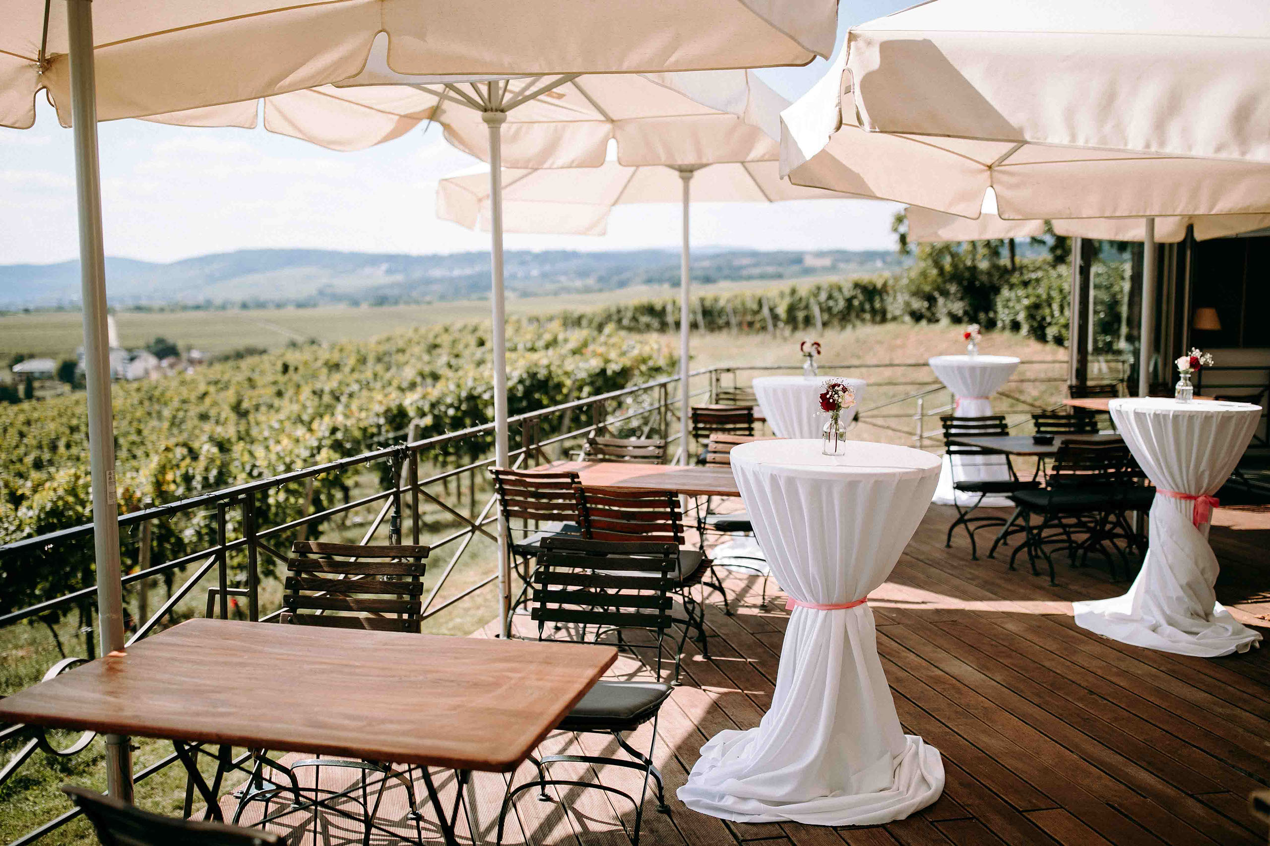 Eleganter Außenbereich von Schloss Johannisberg mit Sonnenschirmen und Blick auf die umliegenden Weinberge