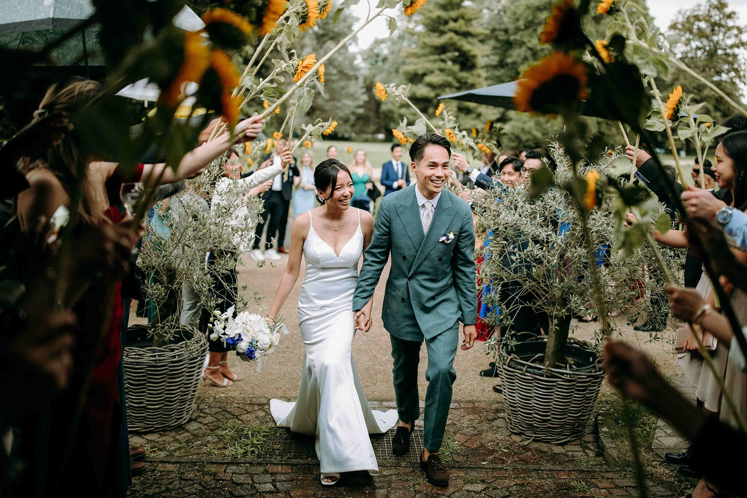 Brautpaar läuft durch Sonnenblumen-Spalier zur Hochzeitsfeier im Golfhaus Bad Homburg