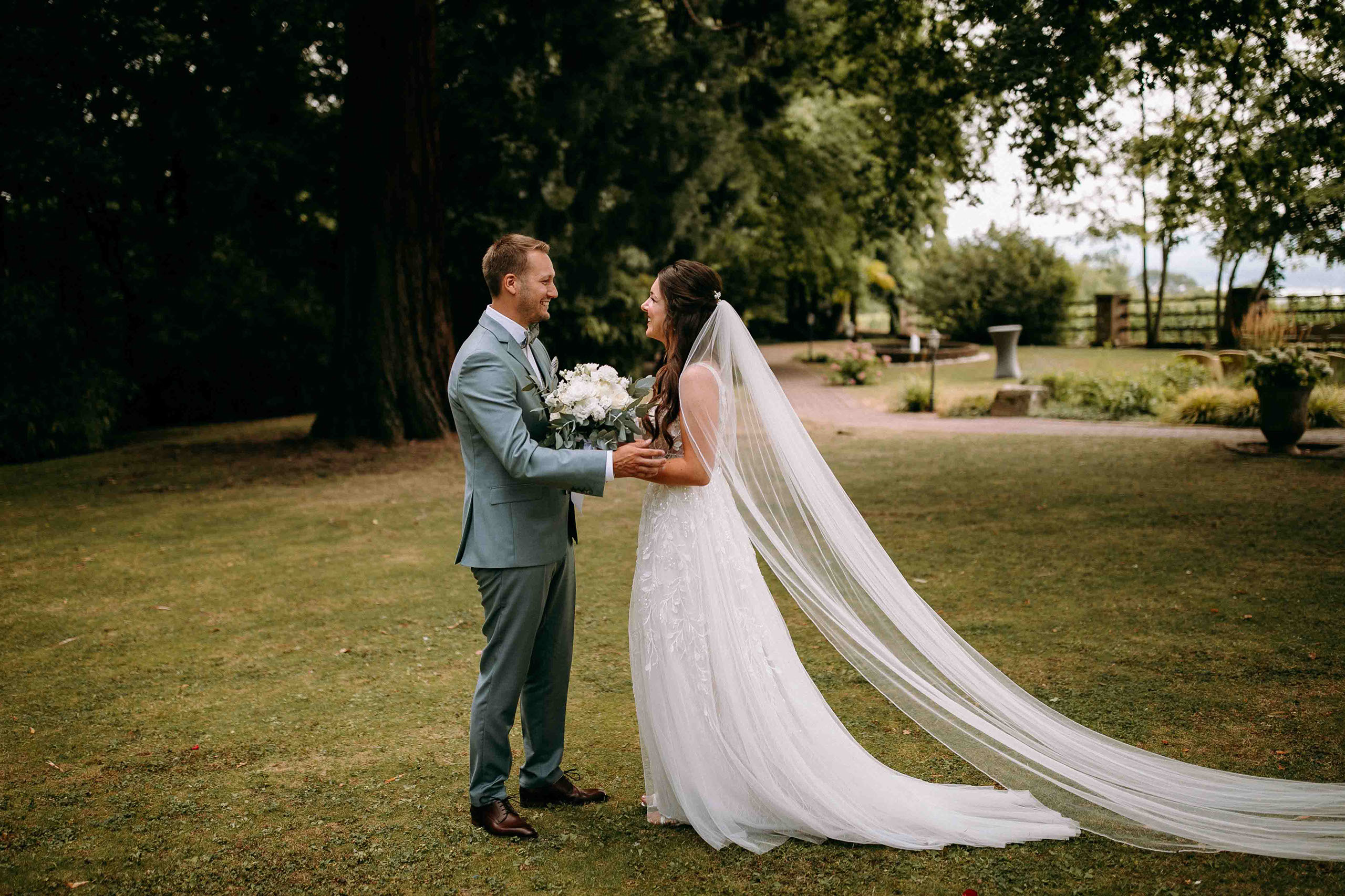 Ergreifender First Look des Brautpaars im Garten der Hochzeitslocation Burg Schwarzenstein – Hochzeitsfotograf Rheingau.