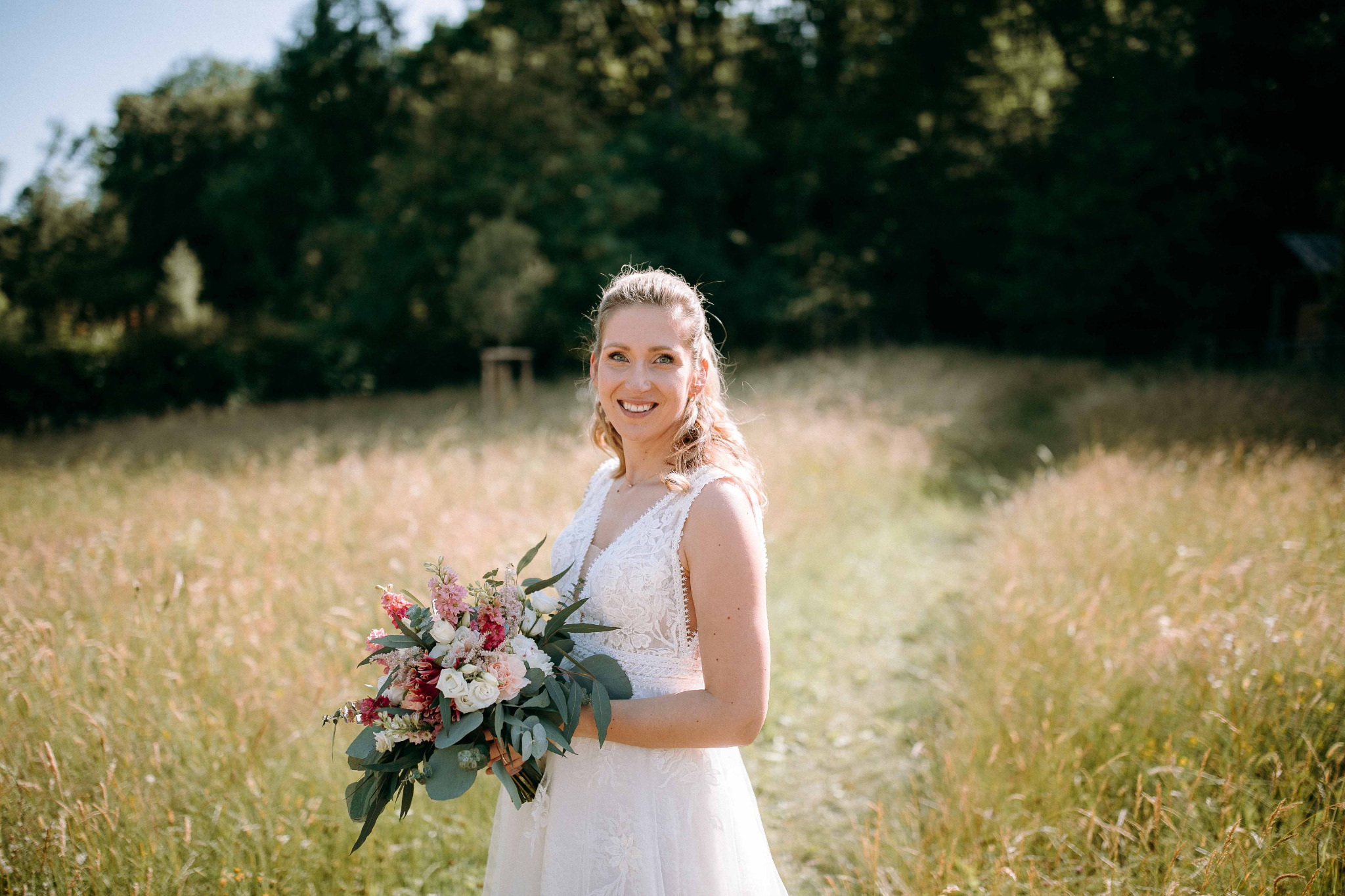 Hochzeitsfoto der Braut in natürlicher Kulisse des Taunus mit Brautstrauß