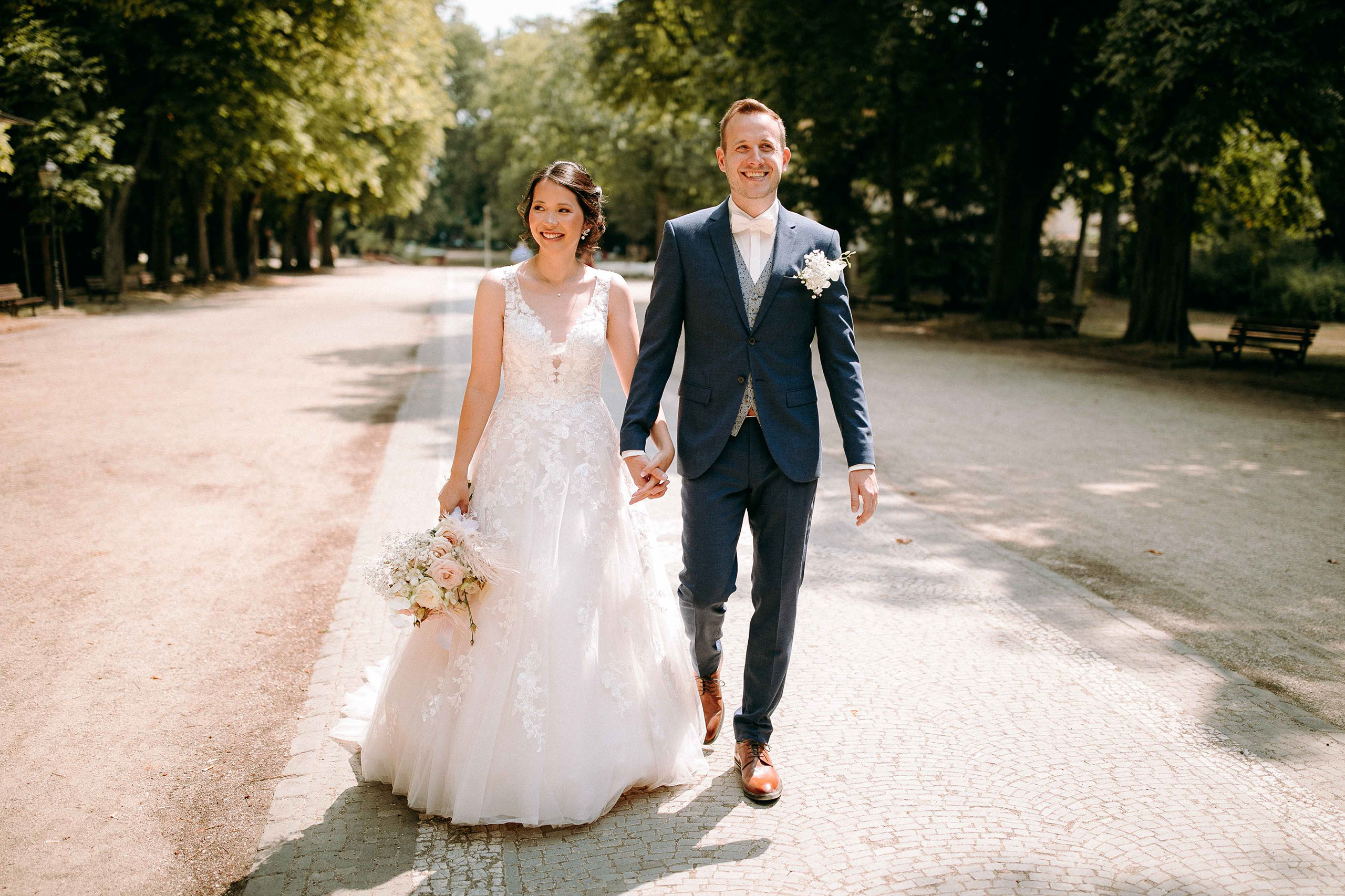 Hochzeitsfoto im Grünen – Brautpaar spaziert Hand in Hand bei Bad Homburg