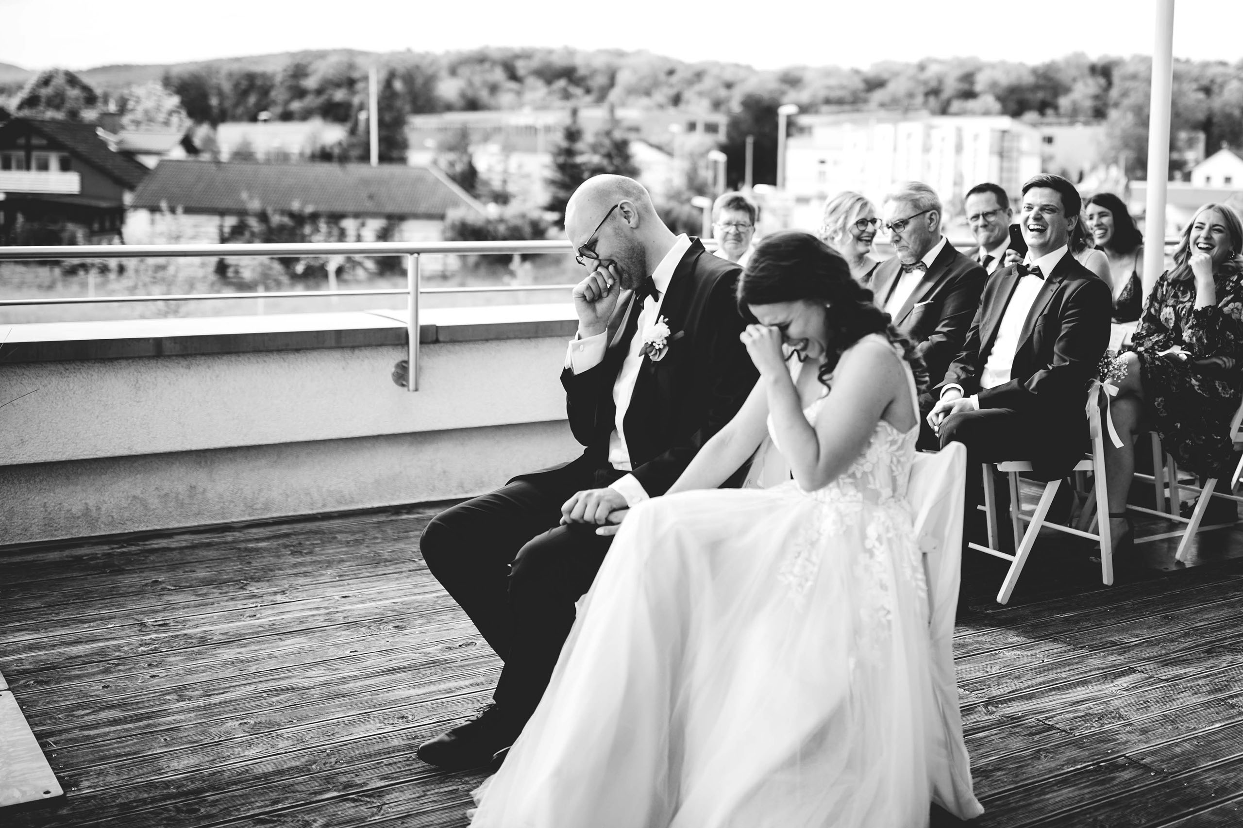 Braut und Braeutigam lachen und weinen gemeinsam waehrend der emotionalen freien Trauung