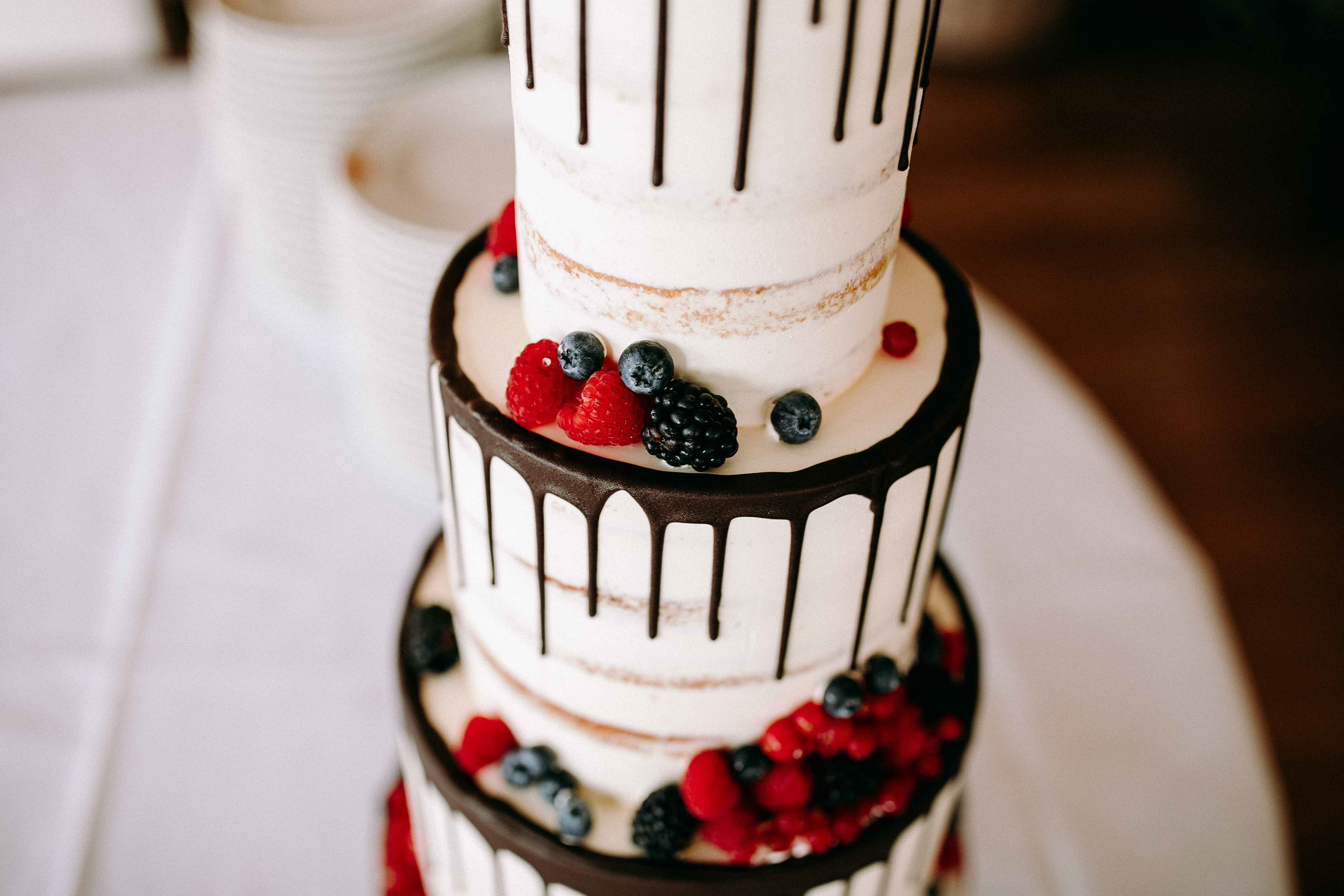 Kreative Hochzeitstorte mit Drip-Effekt und frischen Beeren auf Schloss Johannisberg