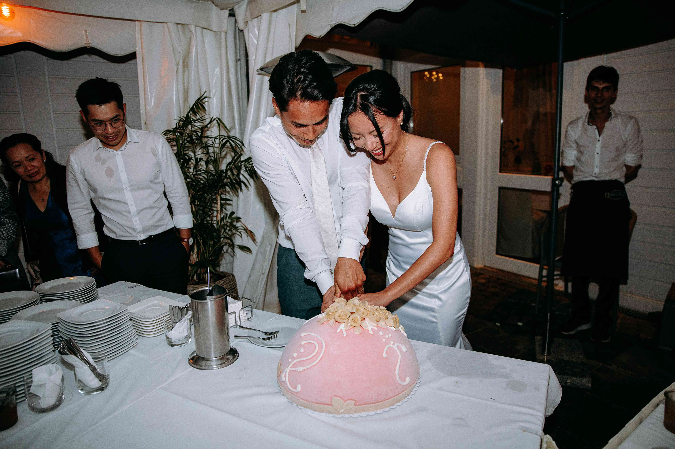 Das Brautpaar schneidet gemeinsam die Hochzeitstorte an – ein unvergesslicher Moment im Golfhaus Restaurant im Kurpark Bad Homburg.