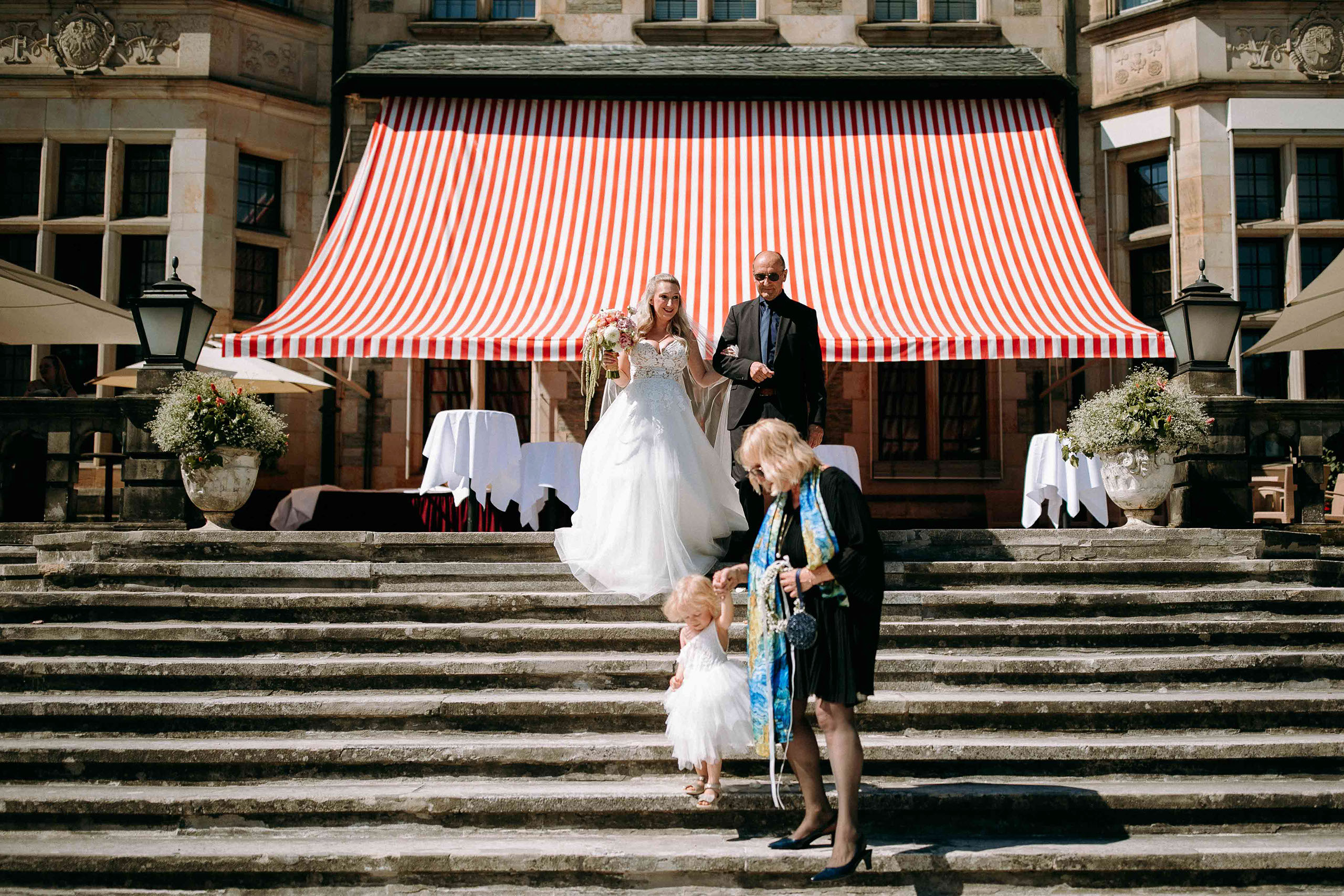 Einzug der Braut mit Vater und Kind über die Schlosstreppe des Schlosshotel Kronberg zur freien Trauung.