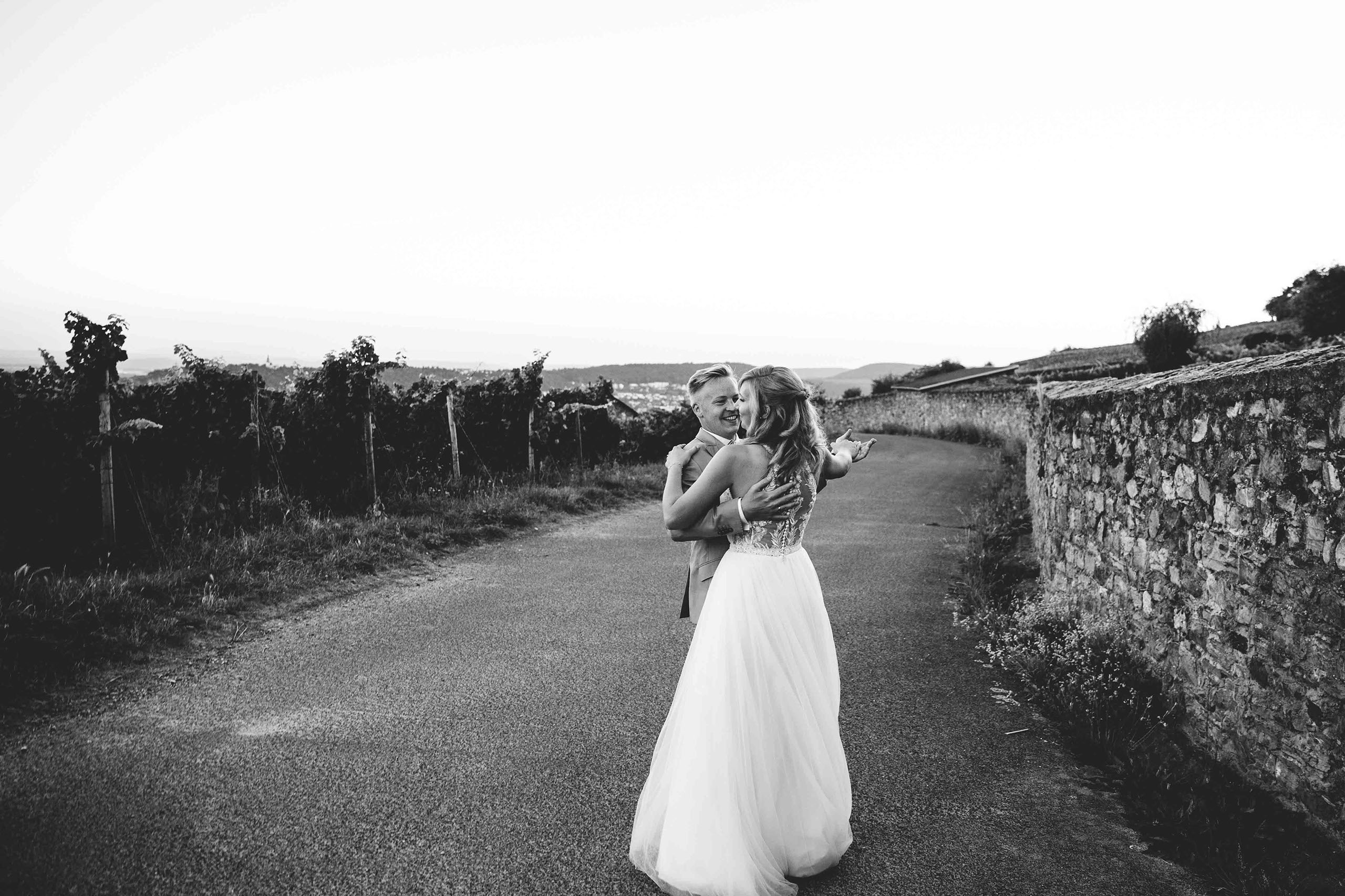 Romantischer Moment beim Hochzeitstanz des Brautpaars zwischen Weinreben in der Abenddämmerung im Weingut Georg Breuer