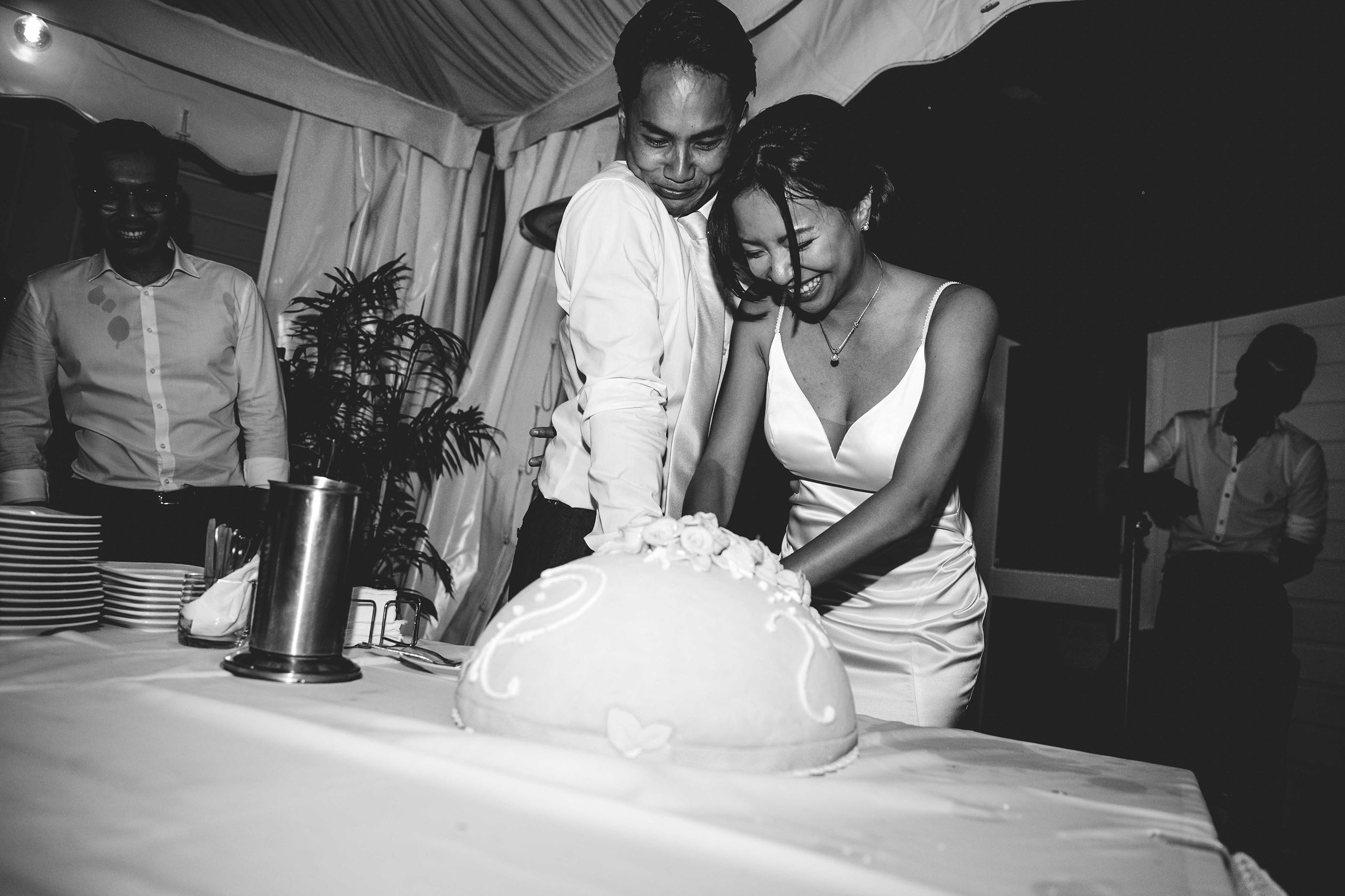 Fröhlicher Moment beim Anschneiden der Torte, festgehalten von einem Hochzeitsfotografen in Bad Homburg.