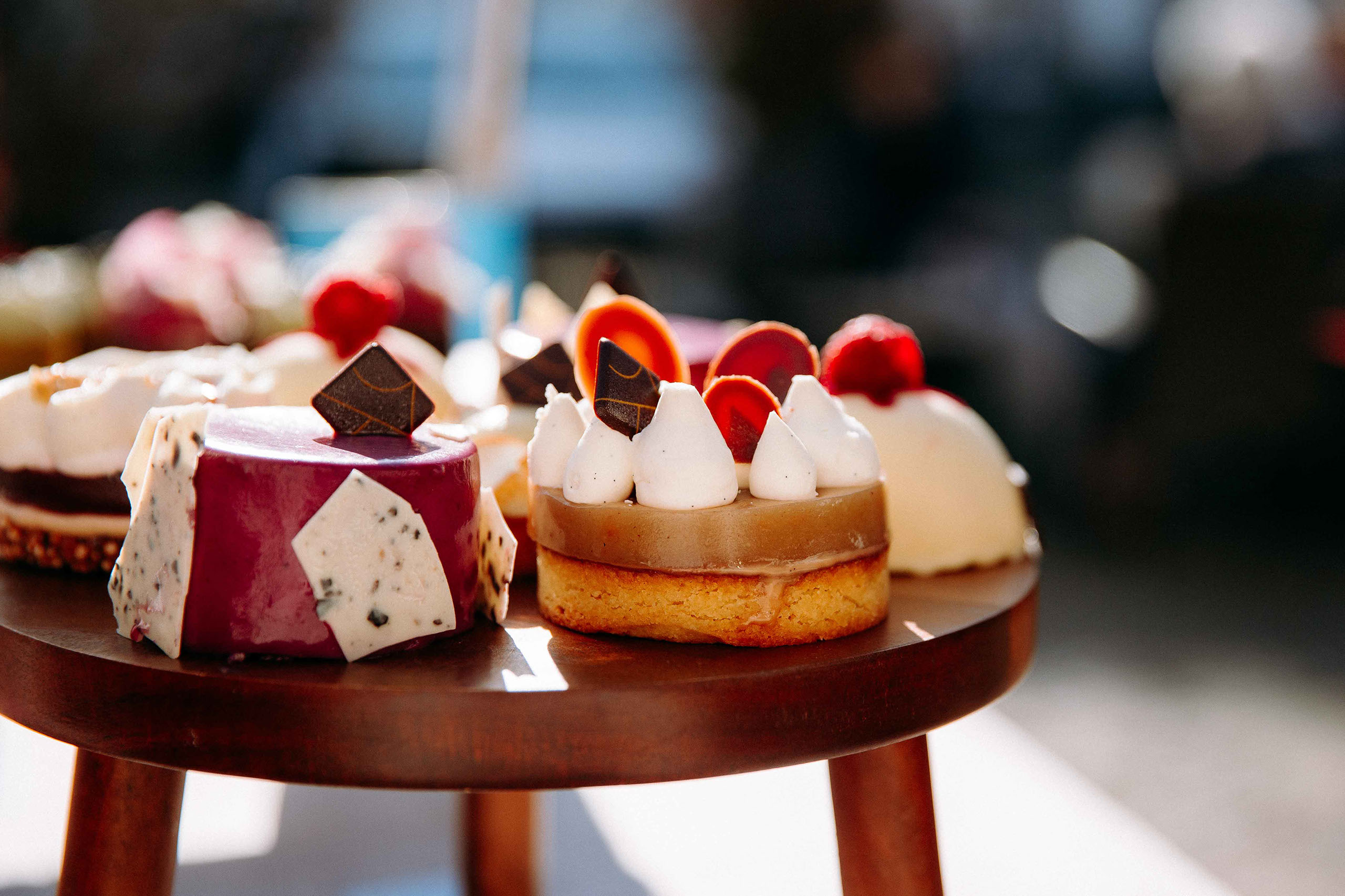 Nahaufnahme von eleganten Hochzeitstörtchen mit Sahnehauben und Früchten – aufgenommen vom Hochzeitsfotograf in der Hochzeitslocation Schloss Re