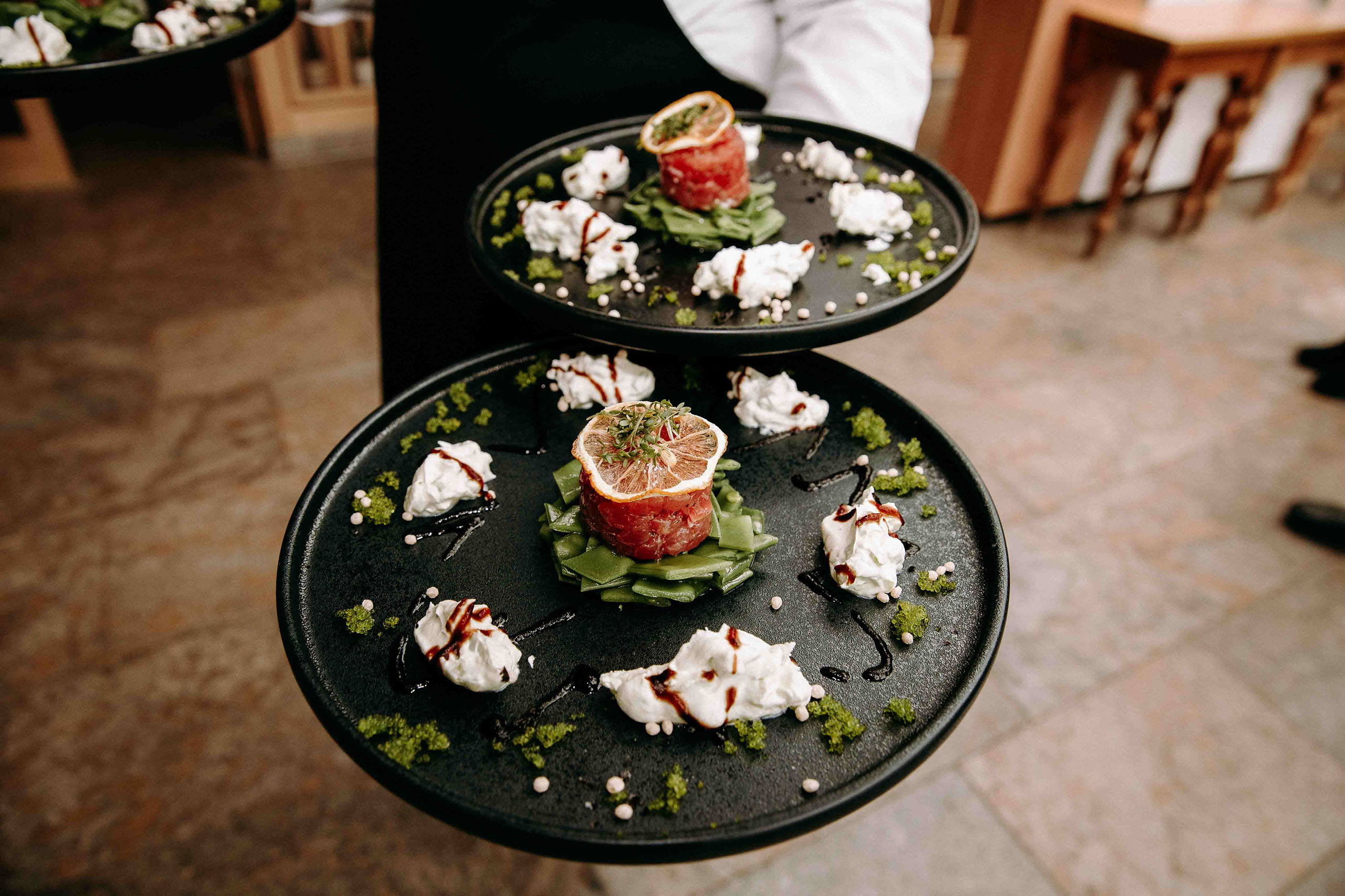 Vorspeise auf dunklem Teller mit Zitrone, Tatar und Frischkäse als Hochzeitsspeise
