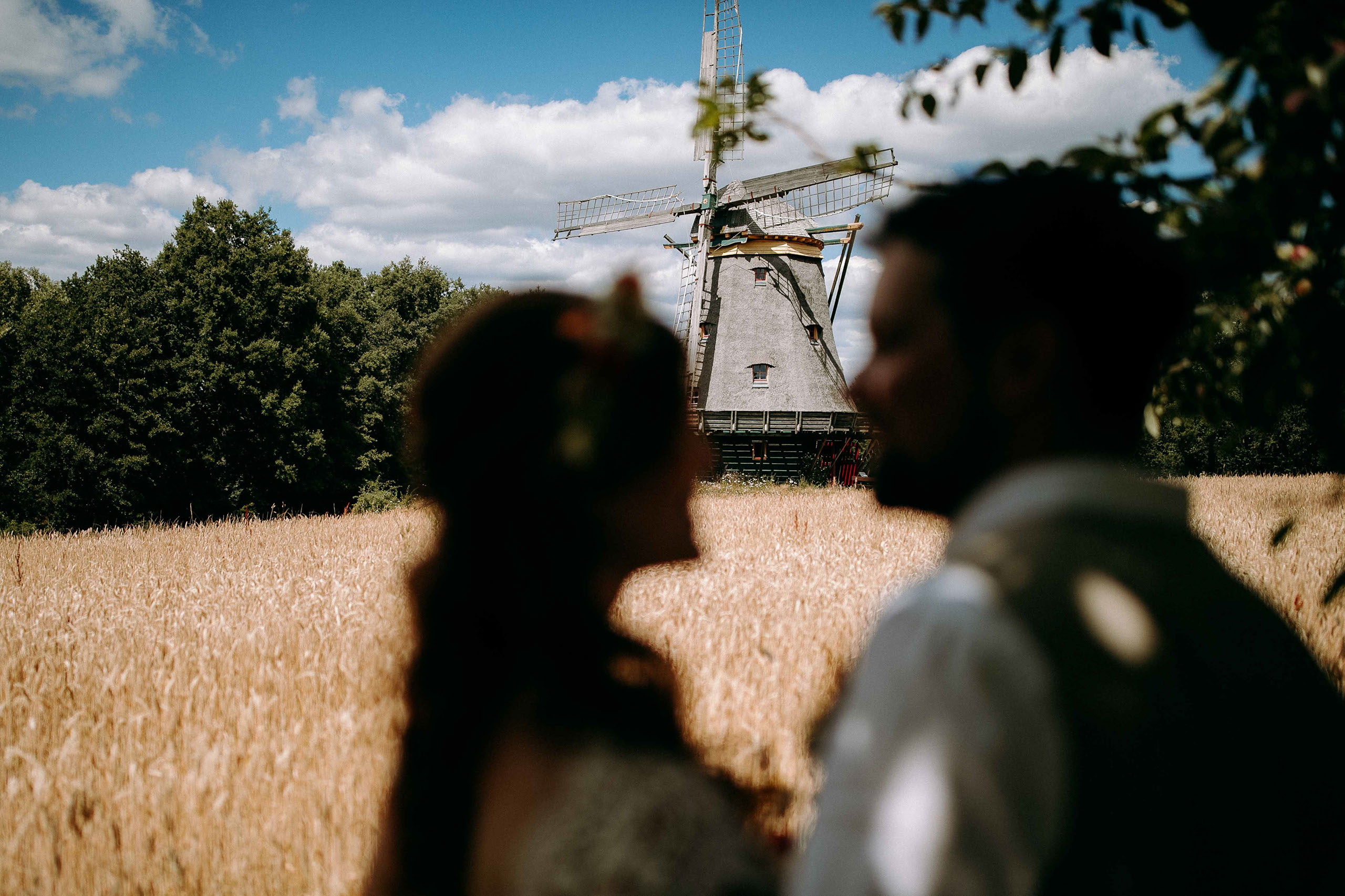 Verschwommenes Paar im Vordergrund mit Fokus auf die Windmühle im Freilichtmuseum Hessenpark.