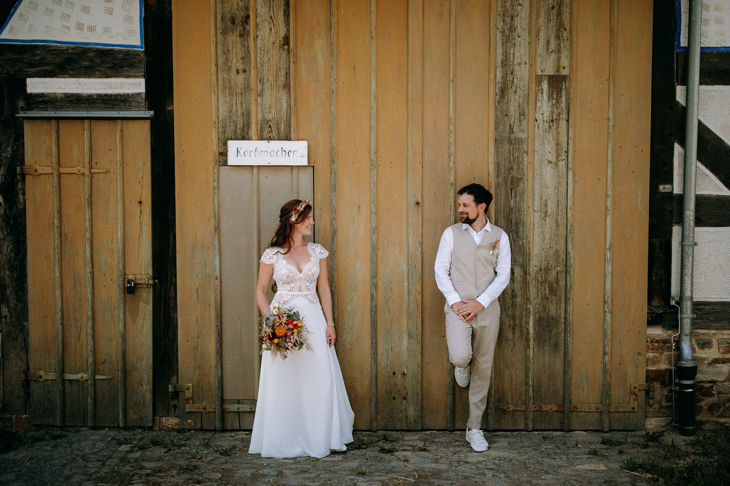 Stilvolles Hochzeitsfoto vor rustikalem Scheunentor mit natürlichem Charme.