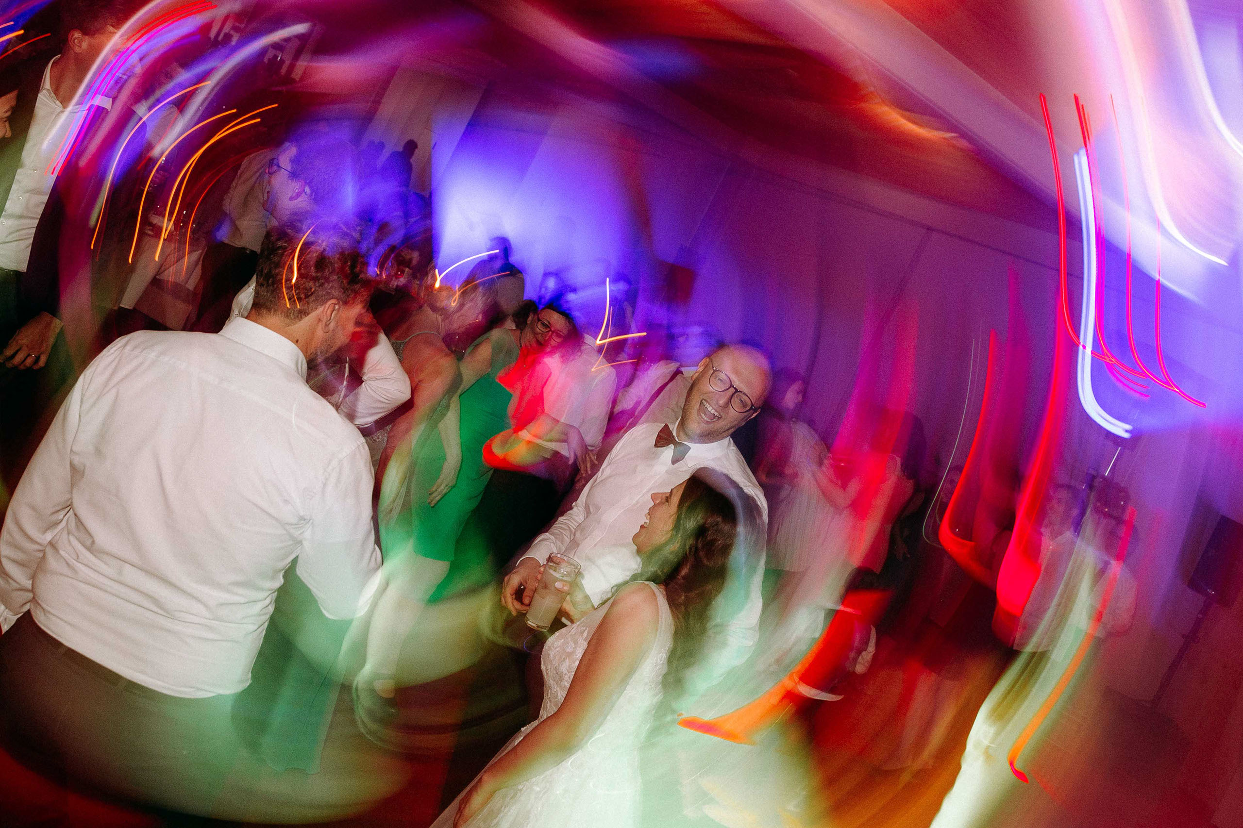 Das Brautpaar tanzt und lacht gemeinsam mit Freunden auf der Tanzfläche im Taktgefühl Eventhaus Friedrichsdorf