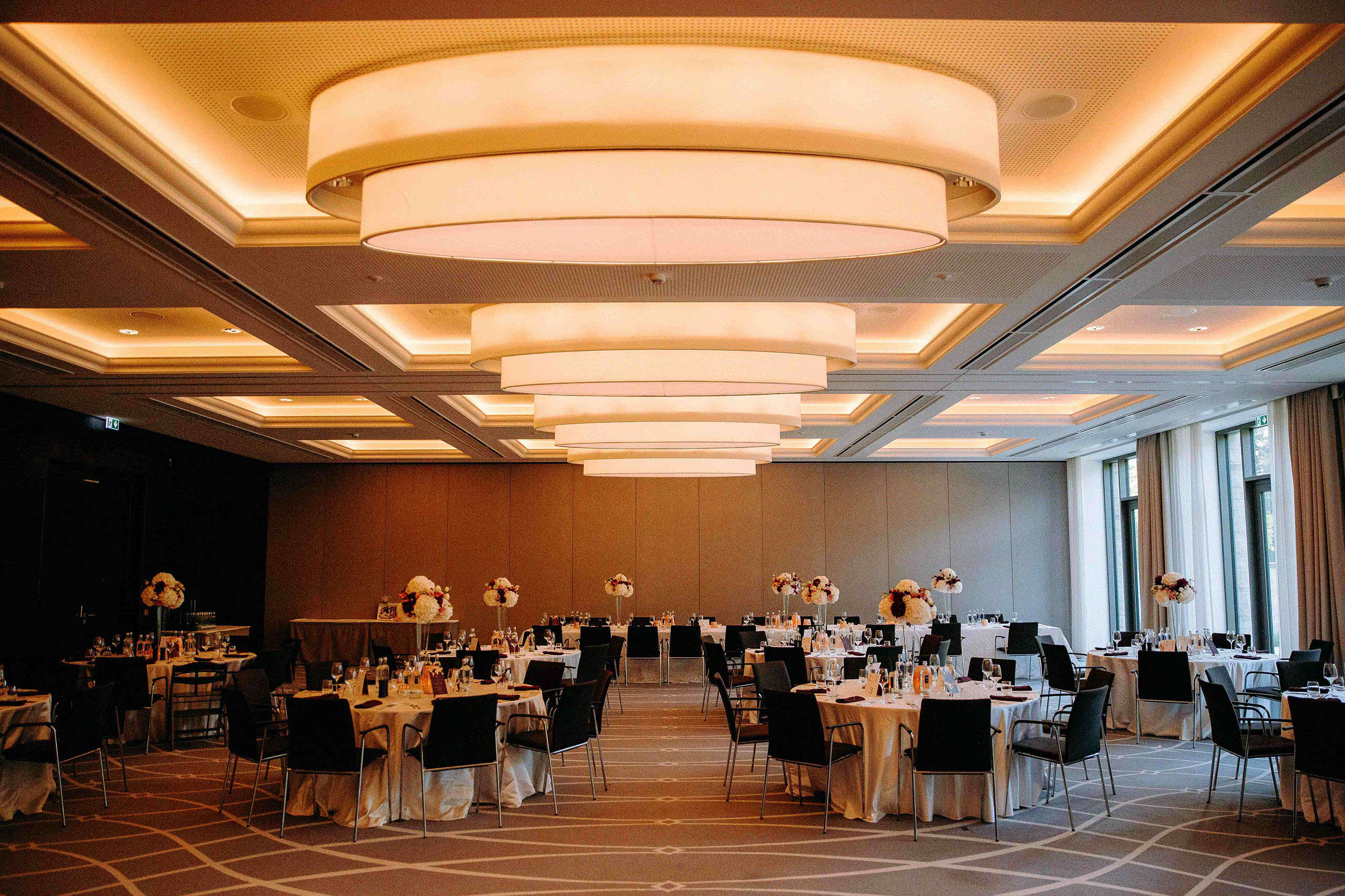 Eleganter Hochzeitssaal mit runden Tischen und stimmungsvoller Beleuchtung im Dorint Hotel Oberursel.