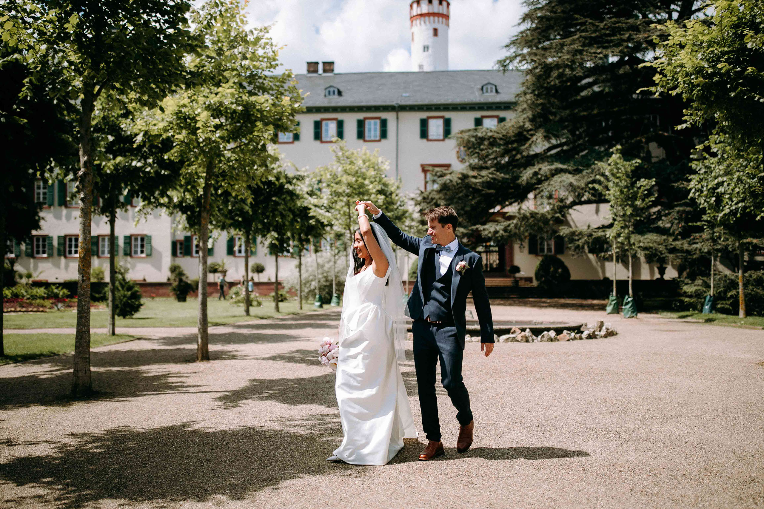 Hochzeitslocation Schloss Bad Homburg – Weisser Saal mit Brautpaar und Turm im Hintergrund