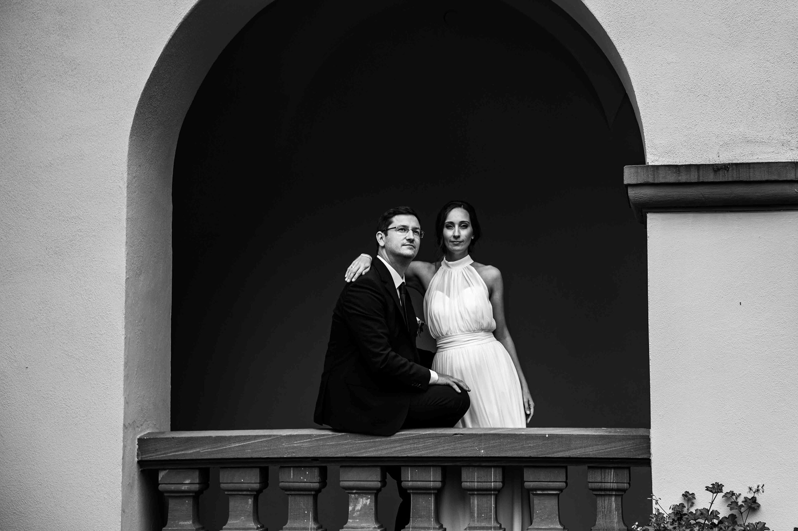 Stilvolles Hochzeitspaar posiert im historischen Torbogen