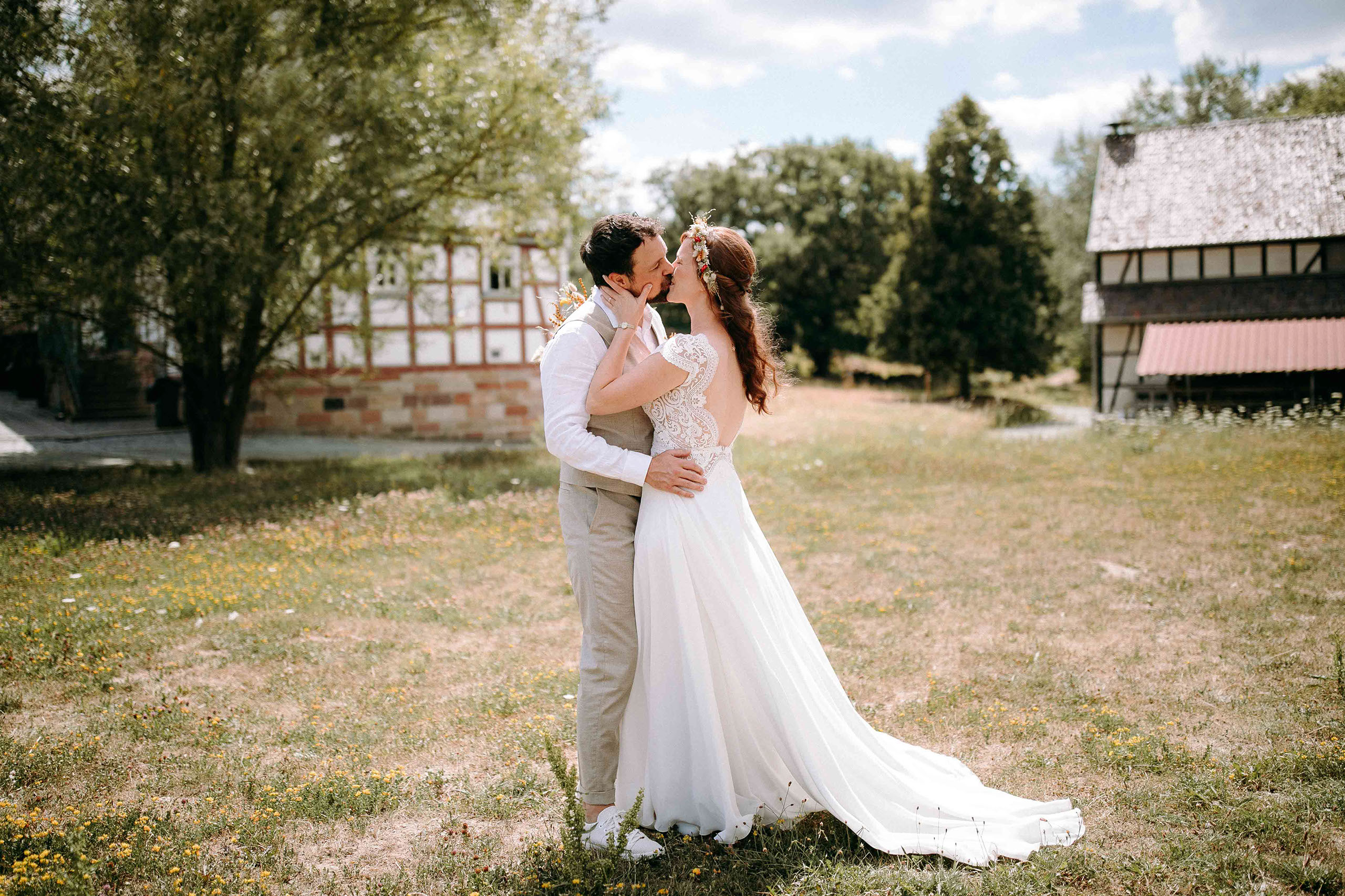 Brautpaar küsst sich zwischen Bäumen – Freilichtmuseum Hessenpark – Hochzeitsfotograf Bad Homburg