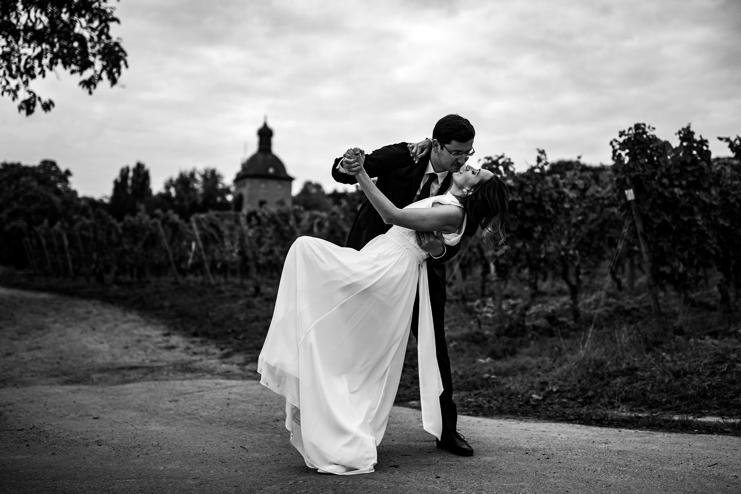 Braut und Bräutigam tanzen vor Vinothek in Schwarz-Weiß