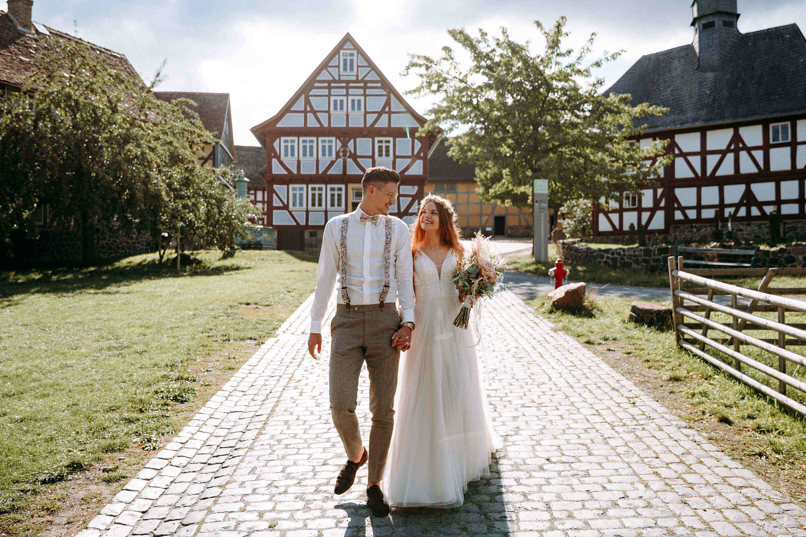 Brautpaar beim Spaziergang durch das Fachwerkdorf im Freilichtmuseum Hessenpark – Hochzeitslocation Bad Homburg.
