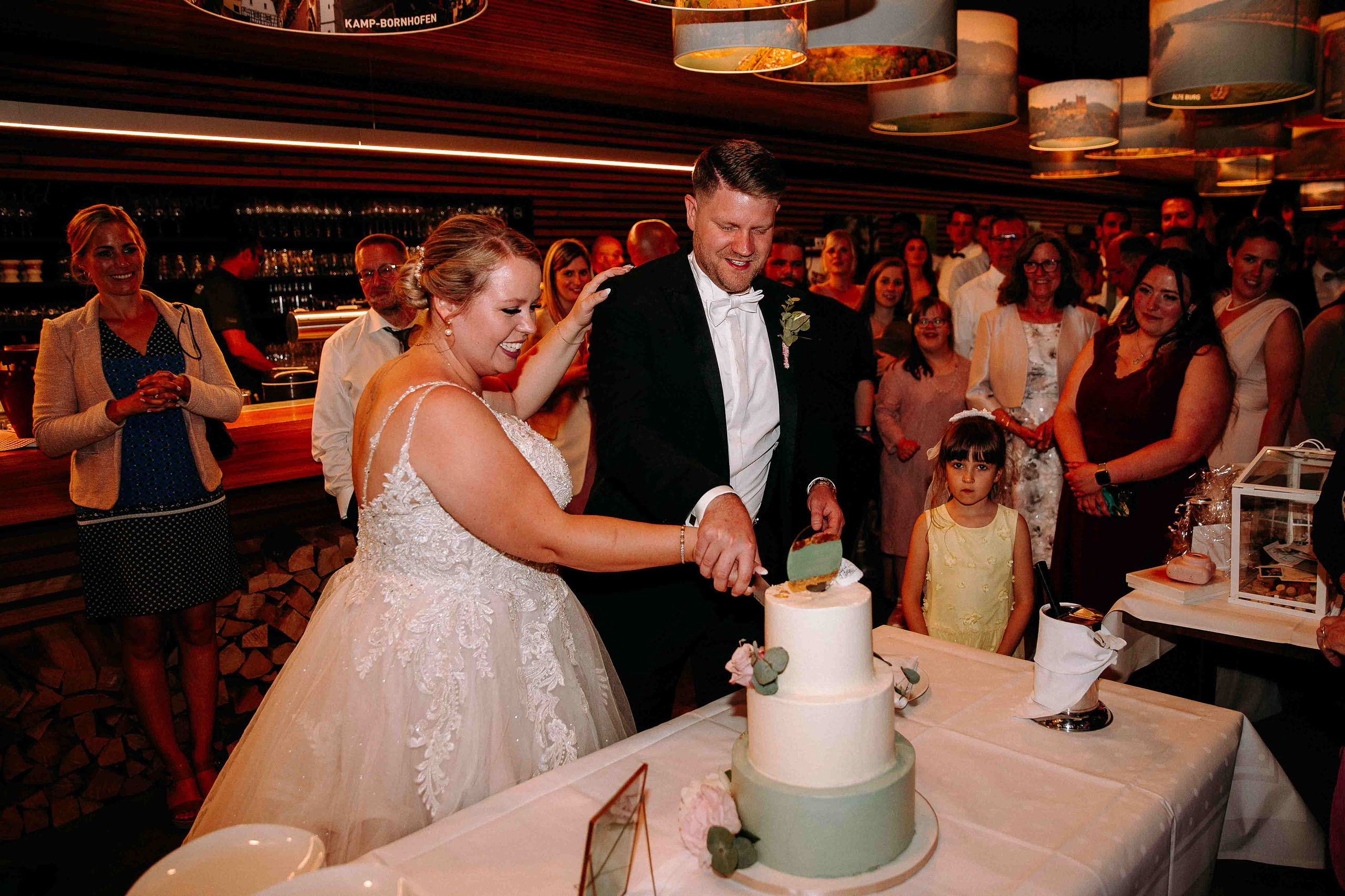 Brautpaar schneidet Torte an bei der Feier in der Hochzeitslocation Am Niederwald – Hochzeitsfotograf Rheingau fängt den Moment ein.