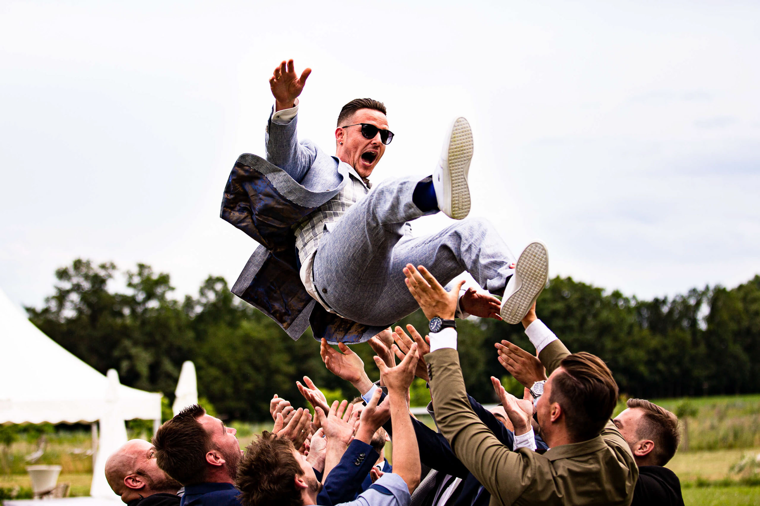 Der Bräutigam wird von seinen Trauzeugen in die Luft geworfen.