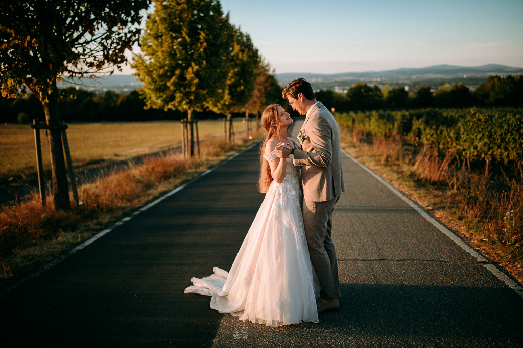 Das Brautpaar steht vor dem offenen Fenster und schaut sich an.
