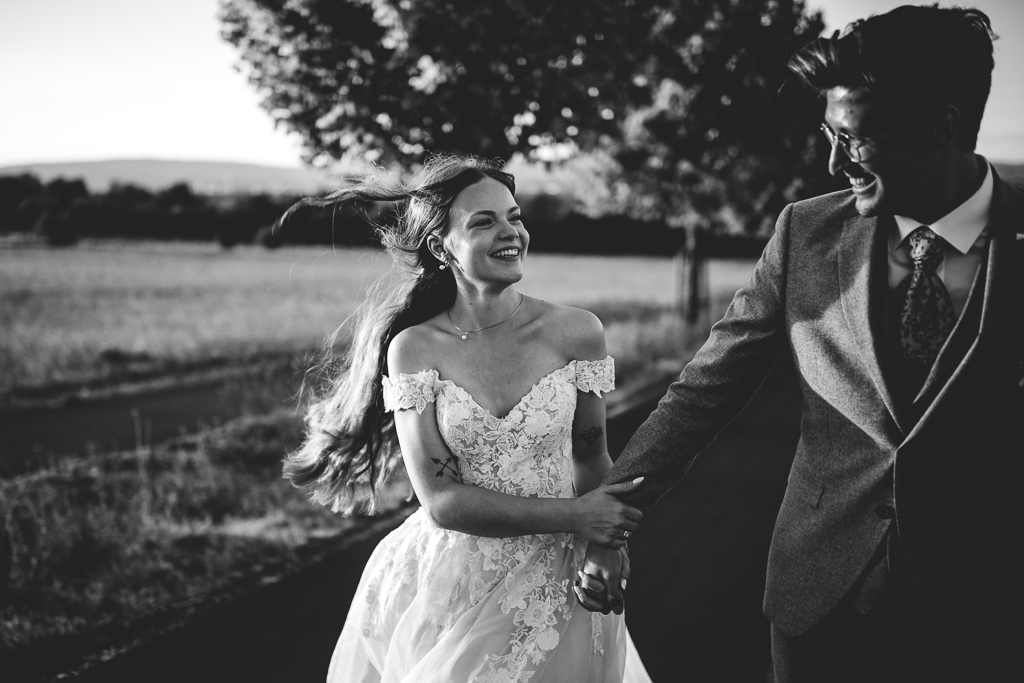 Das Brautpaar steht vor dem offenen Fenster und schaut sich an.