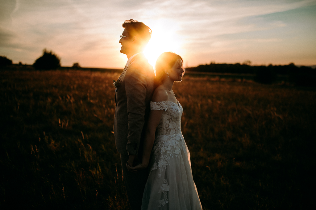Das Brautpaar steht vor dem offenen Fenster und schaut sich an.