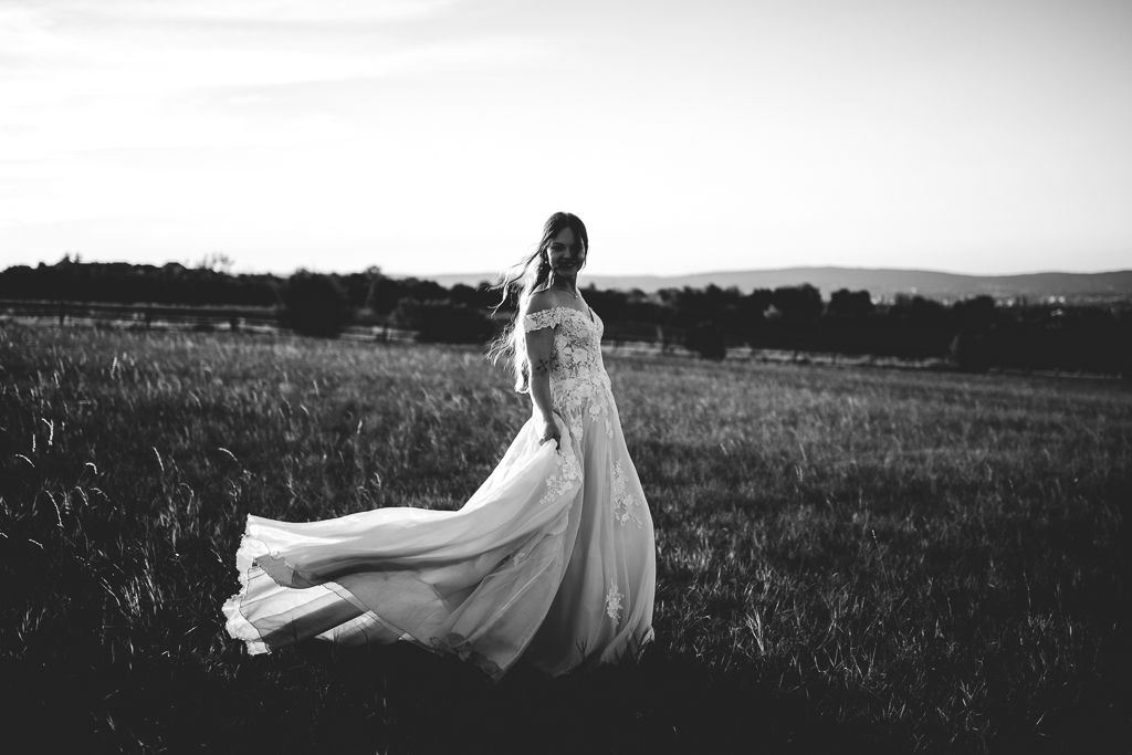 Das Brautpaar steht vor dem offenen Fenster und schaut sich an.