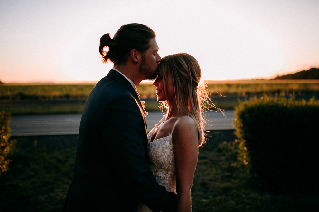 Das Brautpaar steht vor dem offenen Fenster und schaut sich an.