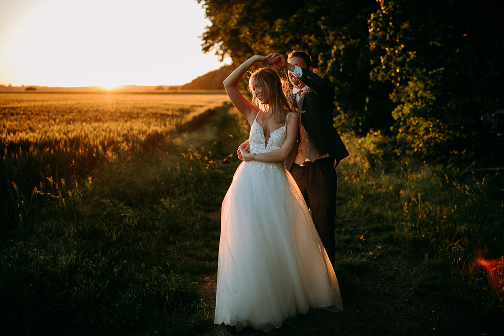 Das Brautpaar steht vor dem offenen Fenster und schaut sich an.