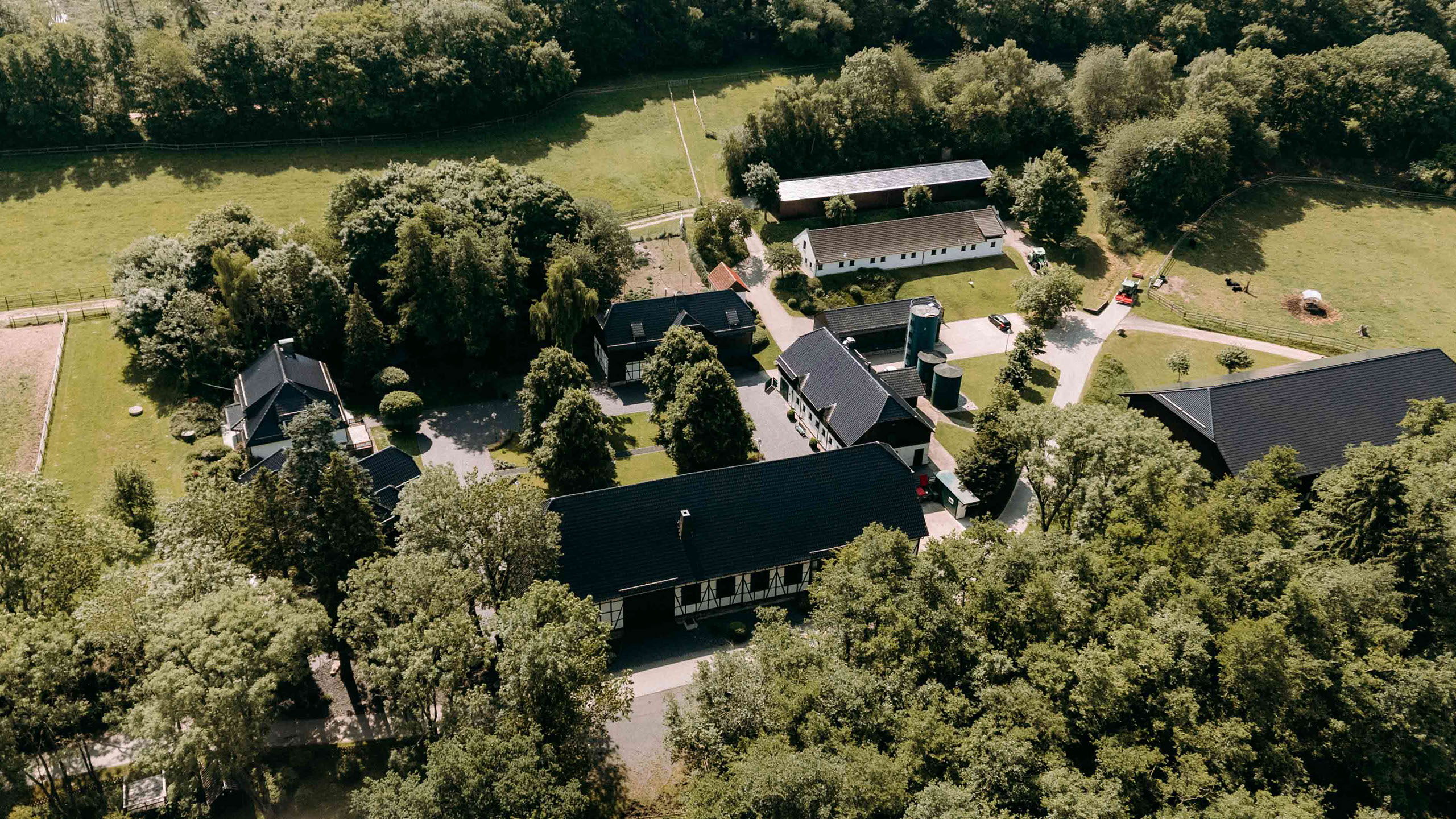 Luftaufnahme des historischen Hofgut Mappen mit Innenhof, Scheunen und Stallungen, eingebettet im Wald – authentische Location für Hochzeiten.