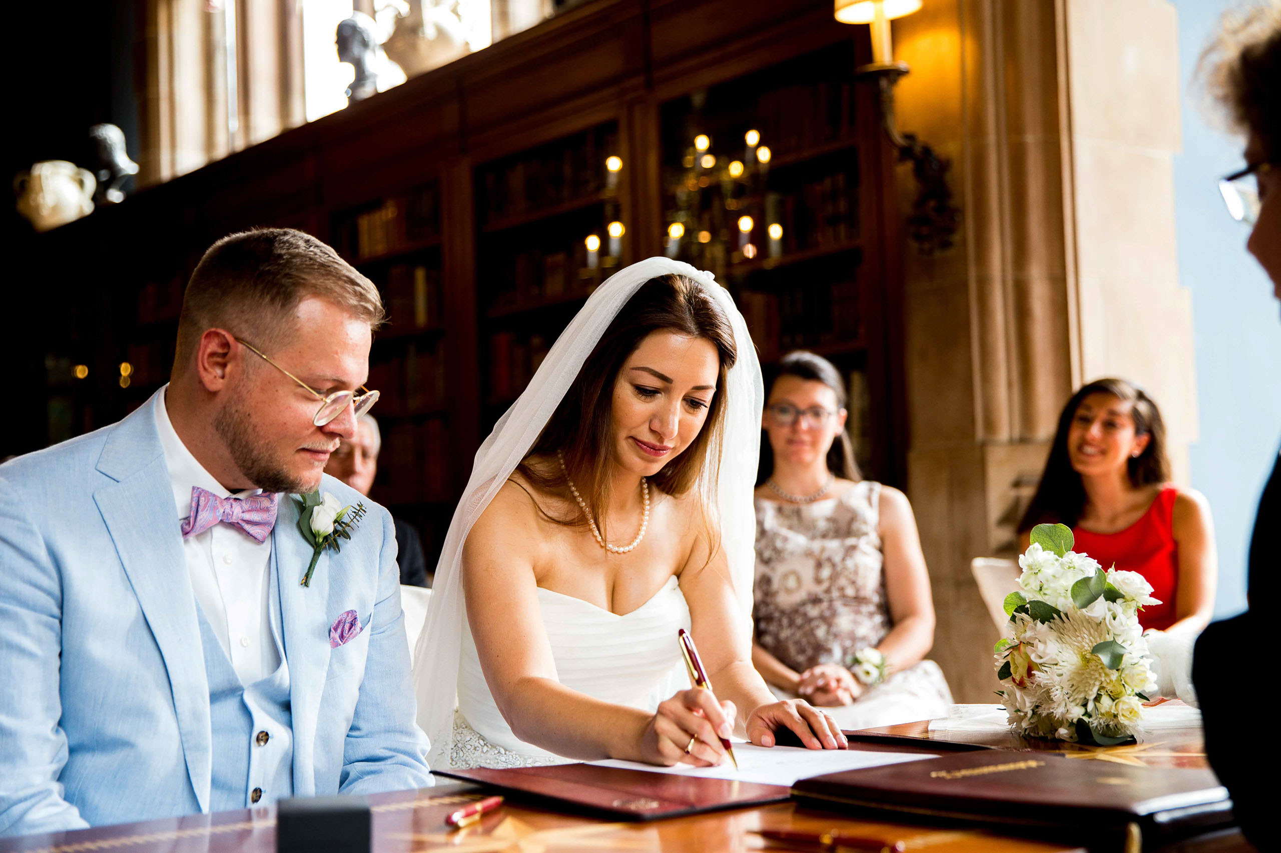 Das Brautpaar bei der Unterschrift im Standesamt Schlosshotel Kronberg in der Bibliothek.